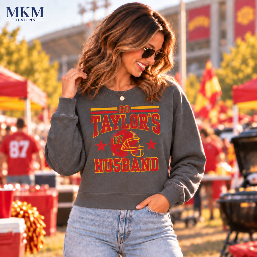 Woman wearing a waist-length Pepper cropped crewneck with distressed Go Taylor's Husband number 87 game day design